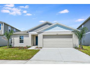 Charming single-story home with a two-car garage, well-maintained lawn, and neatly landscaped flower beds at 13044 Wellspring Dr, Lithia, FL 33547