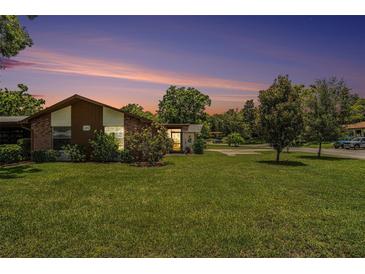 Charming single-story home with a well-manicured lawn and mature trees under a gorgeous twilight sky at 2270 Spruce Ln # B, Palm Harbor, FL 34684