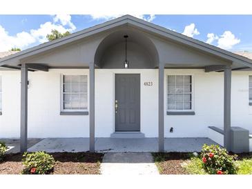 Charming single-story home with a covered porch and freshly painted in bright white at 4823 Ashland Dr, Tampa, FL 33610