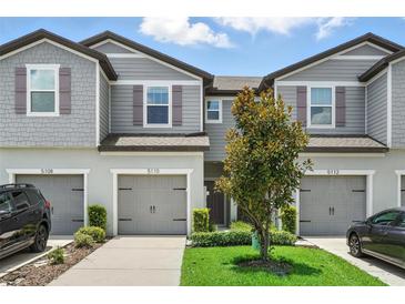 Charming townhome with gray siding, well-maintained landscaping, and a single-car garage at 5110 Sylvester Loop, Tampa, FL 33610