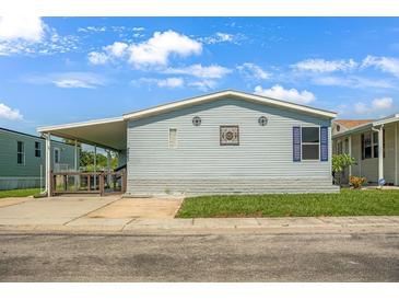 Charming single-story home featuring light blue siding, a covered carport, and a well-maintained lawn at 8443 Fantasia Park Way, Riverview, FL 33578