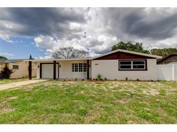 Charming home featuring white exterior, brown trim, and a well-manicured lawn at 3025 Palamore Dr, Holiday, FL 34691