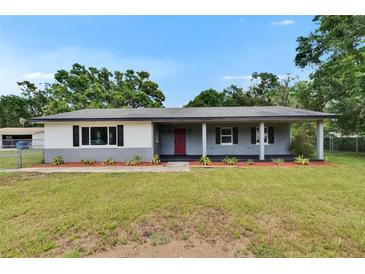 Charming single-story home features a covered porch, red front door and landscaped front yard at 3212 Cork Rd, Plant City, FL 33565