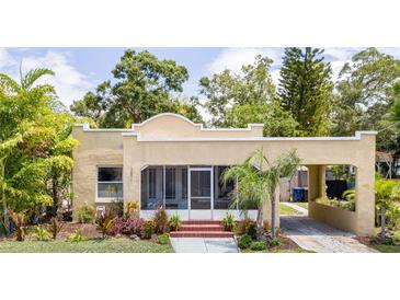 Inviting one-story home with stucco siding, a welcoming porch, and an attached carport for convenient parking at 3611 W Bay To Bay Blvd, Tampa, FL 33611