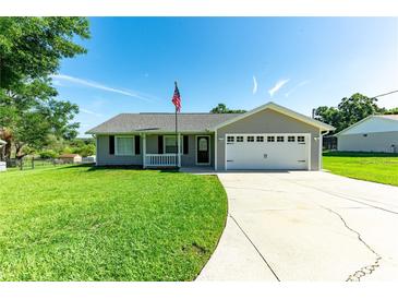 Charming single-story home with a well-manicured lawn, attached two-car garage, and a welcoming front porch at 37113 Waldo Dr, Dade City, FL 33525