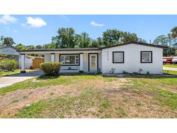 Charming single-story home featuring a bright white exterior, black trim, and a cozy covered carport at 5618 Halifax Dr, Tampa, FL 33615
