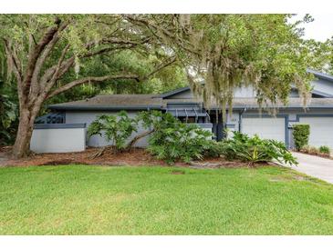 Charming single-story home with a well-manicured lawn and mature trees in a serene setting at 60 Birdsong Ct, Oldsmar, FL 34677