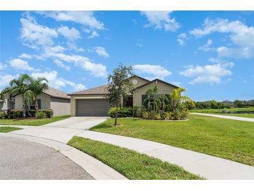 Charming single-story home featuring a well-manicured lawn, and an attached two-car garage at 9814 Quadrangle Ct, Sun City Center, FL 33573