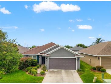 Charming single-story home featuring a well-maintained lawn and a two-car garage at 10909 Kirkwall Port Dr, Wimauma, FL 33598