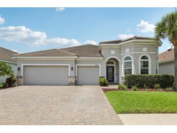 Beautiful single-story home featuring a three-car garage and a well-manicured front yard at 12004 Cinnamon Fern Dr, Riverview, FL 33579
