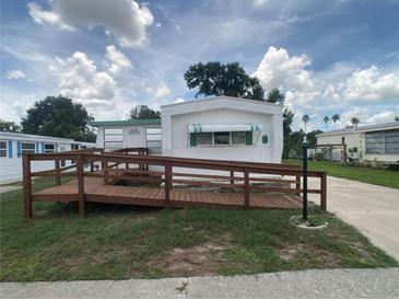 Charming white mobile home with a wooden ramp and awning in a well-maintained community at 1710 7Th Sw St # 82, Ruskin, FL 33570