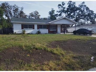 Cozy single story home featuring a covered porch and green lawn at 1922 Marvy Ave, Tampa, FL 33612