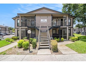Exterior shot of the condo showing the stairs leading to the second floor units and well-maintained landscaping at 4014 Dream Oak Pl # 202, Tampa, FL 33613