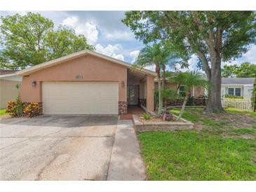 Charming single-story home with a beige exterior, a two-car garage, and beautiful landscaping at 516 7Th Se St, Largo, FL 33771