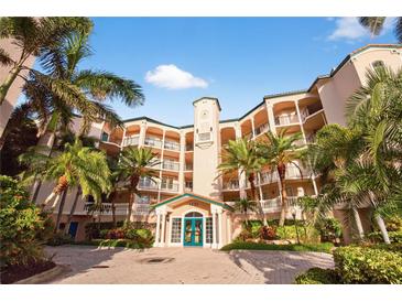 Stunning condo building featuring lush landscaping, arched balconies, and a welcoming entrance at 5430 Eagles Point Cir # 202, Sarasota, FL 34231