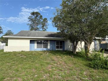 Charming one-story home with blue and white exterior, plus large front lawn at 5479 Mosquero Rd, Spring Hill, FL 34606