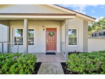 Inviting front entryway with a decorated door, lush landscaping, and charming details at 11799 Raintree Dr, Temple Terrace, FL 33617