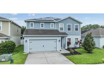 Beautiful two-story home featuring a two-car garage, solar panels, and a well-manicured lawn at 2073 Branding Iron Way, New Port Richey, FL 34655