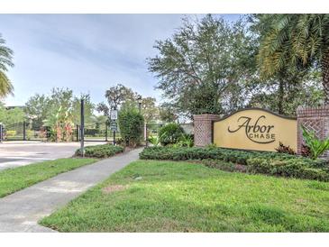 Arbor Chase entrance with brick columns, manicured landscaping, and a gated entrance to the community at 3603 Arbor Chase Dr, Palm Harbor, FL 34683