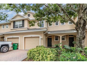 Charming two-story townhome featuring attached garages, brick driveway, and well-maintained landscaping at 3918 Silverlake Way, Wesley Chapel, FL 33544