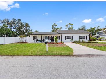 Charming single-story home with a well-manicured lawn, black accents and a quaint front porch at 4401 S Trask St, Tampa, FL 33611