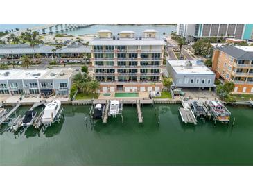 Stunning aerial view of waterfront condo with private boat slips and pool, set against a coastal backdrop at 706 Bayway Blvd # 503, Clearwater, FL 33767