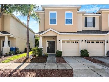 Charming townhome featuring a well-maintained lawn, a one-car garage, and neutral colored stucco at 1031 Andrew Aviles Cir, Tampa, FL 33619