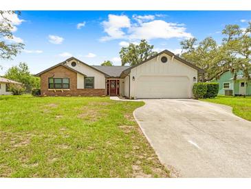 Charming single-story home featuring a 2 car garage and well-manicured front yard at 2141 Coachman Rd, Spring Hill, FL 34608