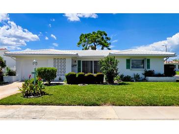 Charming single-story home with a well-manicured lawn, clean white exterior, and lush landscaping at 3605 100Th N Ter, Pinellas Park, FL 33782