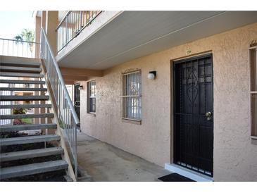 Exterior view of a condo entrance with a black security door, accessible by stairs leading to the second level at 4702 Michael Ct # 139, Tampa, FL 33614