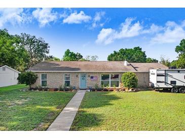 Charming single-story home featuring a well-maintained lawn and stone accents under a sunny, blue sky at 901 Strawberry Ln, Brandon, FL 33511