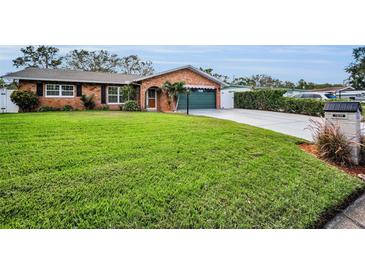 Charming brick home featuring lush green lawn, well-manicured landscaping, and a convenient garage at 11236 116Th St, Largo, FL 33778