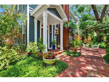 Charming home featuring a brick pathway to the front door with lush, verdant landscaping at 2404 W Jetton Ave, Tampa, FL 33629