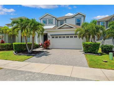 Beautiful two-story home boasts a paved driveway, a two-car garage, and tropical landscaping at 315 Blackrock Ln, Apollo Beach, FL 33572