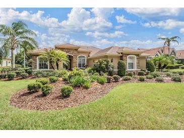 Beautiful single-story home featuring stone accents, a tile roof, and lush landscaping at 33744 Americana Ave, Dade City, FL 33525