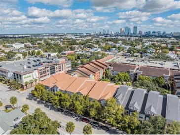 A captivating aerial view of a neighborhood with a city skyline in the background on a sunny day at 410 S Armenia Ave # 926, Tampa, FL 33609