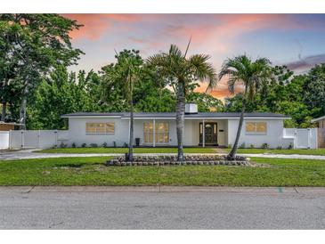 Charming single-story home featuring mature landscaping and a welcoming facade with a black front door at 521 51St S Ave, St Petersburg, FL 33705