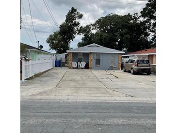 Charming single-story home with a spacious driveway, stone columns, and inviting front porch seating at 7022 Hubert, Tampa, FL 33614