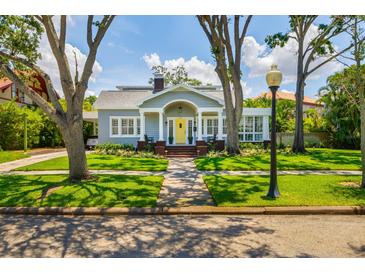 Charming single-story home with a landscaped front yard, sidewalk, and inviting yellow front door at 842 S Boulevard, Tampa, FL 33606