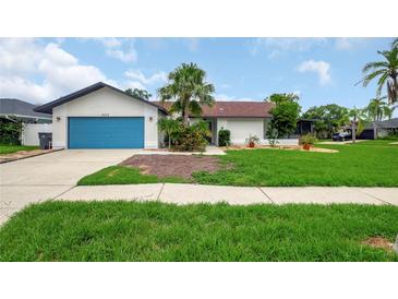 Charming single-story home with a lush lawn and inviting blue garage door, perfect for curb appeal at 8635 Chadwick Dr, Tampa, FL 33635