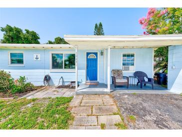 Charming, single-story home with blue exterior, covered entry, and walkway leading to the front door at 10436 117Th Dr, Largo, FL 33773