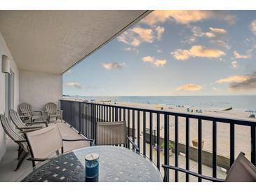 Relax on the balcony with a table and chairs overlooking the beach with ocean views at 14300 Gulf Blvd # 104, Madeira Beach, FL 33708