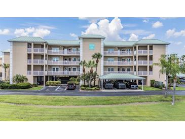 A charming condo building with a well-manicured lawn and covered parking at 399 150Th Ave # 315, Madeira Beach, FL 33708
