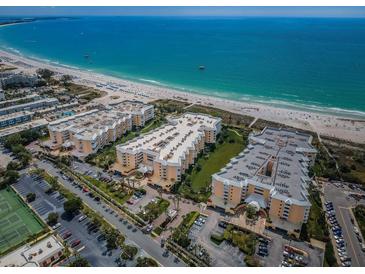 Stunning aerial view of beachfront condo complex with pristine white sands and turquoise ocean waters at 6600 Sunset Way # 118, St Pete Beach, FL 33706