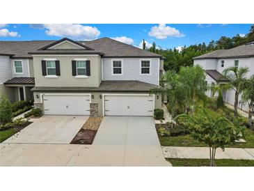 Charming townhome with a two-car garage and well-maintained landscaping at 2155 Cerulean Sky Dr, Lutz, FL 33558