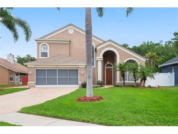 Charming two-story home with a well-manicured lawn, beautiful landscaping, and attached two car garage at 277 Wood Dove Avenue, Tarpon Springs, FL 34689