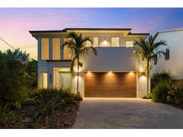 Contemporary two-story home featuring a statement wood garage door, manicured landscaping, and modern architectural details at 2803 W Aquilla St, Tampa, FL 33629