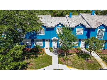 Charming blue townhome with a well-manicured lawn and a welcoming walkway to the front door at 3350 Fox Hunt Dr, Palm Harbor, FL 34683