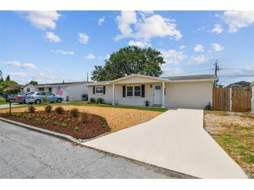 Charming single-story home featuring a well-manicured lawn, fresh mulch, and a long driveway at 3850 Carioca Rd, Holiday, FL 34691
