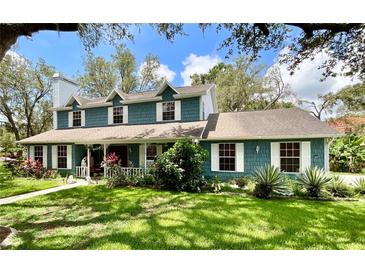 Charming two-story home featuring a well-manicured lawn and beautiful landscaping at 8834 Whispering Oaks Trl, New Port Richey, FL 34654